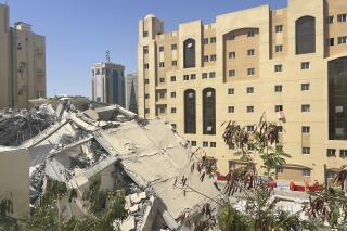The ruins of a collapsed building are seen in Doha, Qatar, Wednesday, March 22, 2023. A building collapsed Wednesday in Qatar's capital, as searchers clawed through the rubble to check for survivors, authorities said. (AP Photo/Lujain Jo)