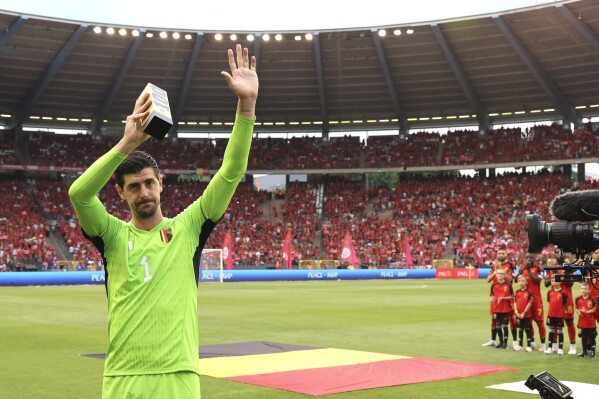 Belgium's goalkeeper Thibaut Courtois holds a trophy as he celebrates his 100th match during the Euro 2024 group F qualifying soccer match between Belgium and Austria at the King Baudouin Stadium in Brussels, Saturday, June 17, 2023. (AP Photo/Geert Vanden Wijngaert)