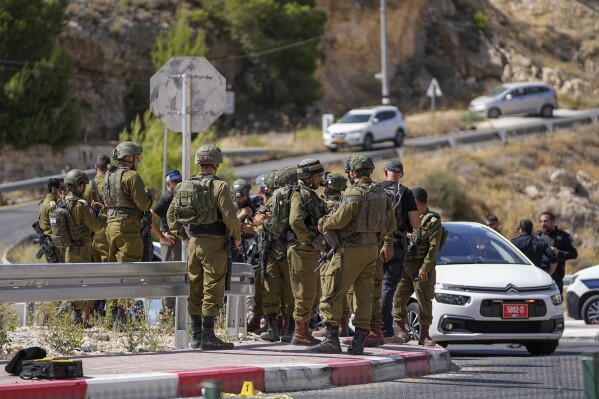Israeli security forces inspect the scene of a shooting attack near the West Bank Jewish settlement of Tekoa, Sunday, July 16, 2023. Israeli authorities say a Palestinian gunman opened fire on a car in the occupied West Bank wounding three including two girls and sparking a manhunt. (AP Photo/Ohad Zwigenberg)