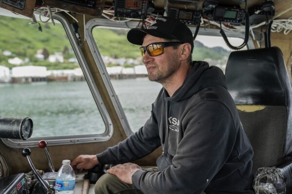 Darren Platt, captain of the Agnes Sabine, steers the boat toward a refueling station, Friday, June 23, 2023, in Kodiak, Alaska. Retaining deckhands is key for Platt and he says he focuses on keeping crew members as comfortable as possible so that they might return again to work the following season while teaching them the skills they need to perform their job on the boat. (AP Photo/Joshua A. Bickel)