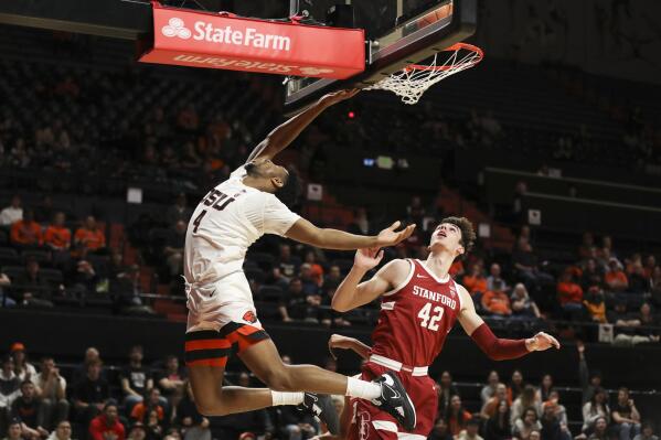 Oregon State guard Dexter Akanno (4) drives to the basket past Stanford forward Maxime Raynaud (42) during the first half of an NCAA college basketball game in Corvallis, Ore., Thursday, March 2, 2023. (AP Photo/Amanda Loman)