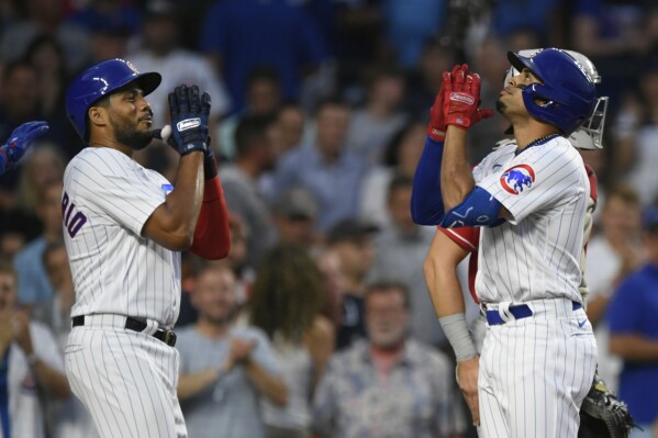 Chicago Cubs' Christopher Morel right, celebrates with teammate Jeimer Candelario left, at home plate after hitting a two-run home run during the third inning of a baseball game against the Cincinnati Reds, Wednesday, Aug. 2, 2023, in Chicago. (AP Photo/Paul Beaty)