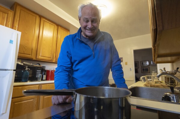 Ed Yaker boils water on a Copper stove, an electric induction stove, on Feb. 10, 2025, in New York. (AP Photo/John Minchillo)