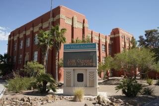 FILE - A sign announces that the Las Vegas Academy is closed, Wednesday, July 22, 2020, in Las Vegas. A battle over getting a school vouchers question before voters in Nevada is returning to state court, with a lawsuit aiming to block the state's top elections official from putting measures on the ballot to let parents use state money to pay for private school tuition. (AP Photo/John Locher, File)
