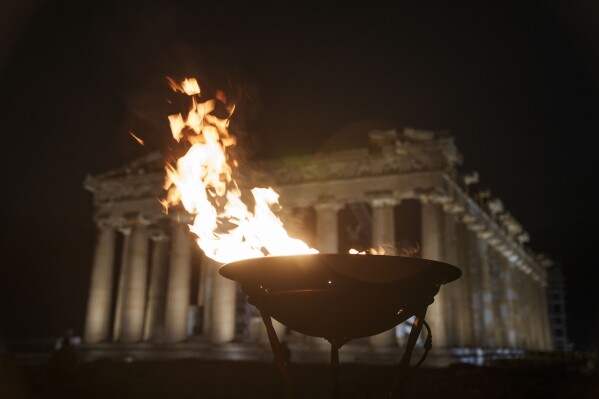 A cauldron with the Olympic flame burns in front of the ancient Parthenon temple at the Acropolis hill, Friday, April 19, 2024. The flame that will burn at the summer Olympics is spending the night at the ancient Acropolis in Athens, a week before its handover to Paris 2024 organizers. (Ǻ Photo/Petros Giannakouris)