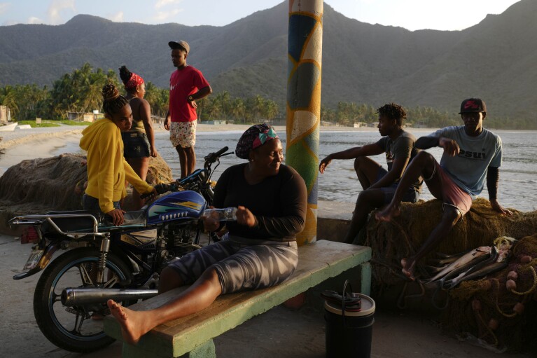Fisherwoman Yennifer Ashe waits with her team to learn if there are fish in their nets to retrieve, in Chuao, Venezuela, early evening Thursday, June 8, 2023. The fishermen and fisherwomen work in teams of four or five boats. (AP Photo/Matias Delacroix)