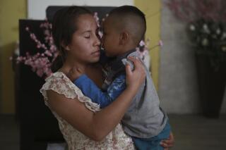 Una mujer abraza a un niño en el albergue del Buen Samaritano, el miércoles 30 de marzo de 2022, en Ciudad Juárez, México. (AP Foto/Christian Chávez)