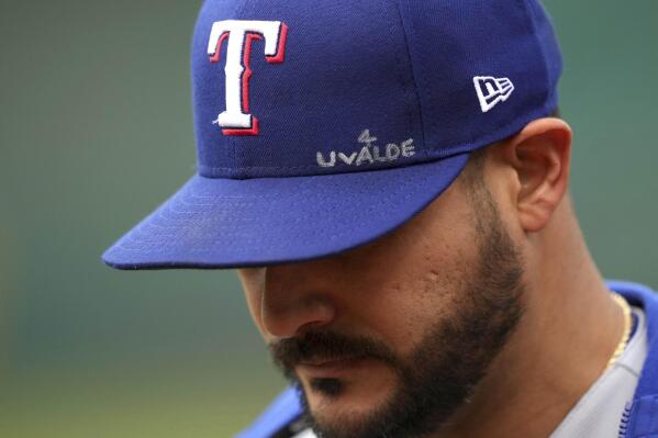 Texas Rangers' Martin Perez walks to the dugout with an inscription on his hat dedicated to the victims of the Uvalde, Texas, school shooting, before the team's baseball game against the Oakland Athletics on Thursday, May 26, 2022, in Oakland, Calif. (AP Photo/Darren Yamashita)
