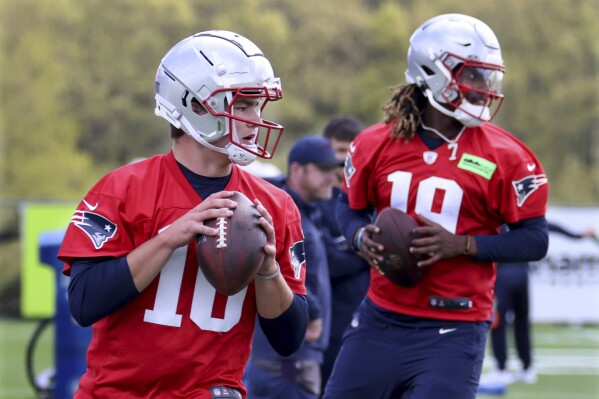 New England Patriots first-round draft pick quarterback Drake Maye, left, and sixth round draft pick quarterback Joe Milton, III, right, run passing drills during the NFL football team's rookie minicamp Saturday, May 11, 2024, in Foxborough, Mass. (AP Photo/Mark Stockwell)