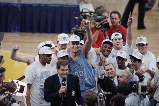FILE - In this April 5, 1993, file photo, North Carolina's Eric Montross (00) raises his arm as he celebrates a win against Michigan in the NCAA Final Four championship basketball game in New Orleans. The Montross family says Eric Montross has begun treatments for cancer. The family issued a statement through the school on Saturday, March 25, 2023 announcing the 51-year-old's diagnosis, though it didn't specify the nature of the cancer. (AP Photo/Bob Jordan, File)