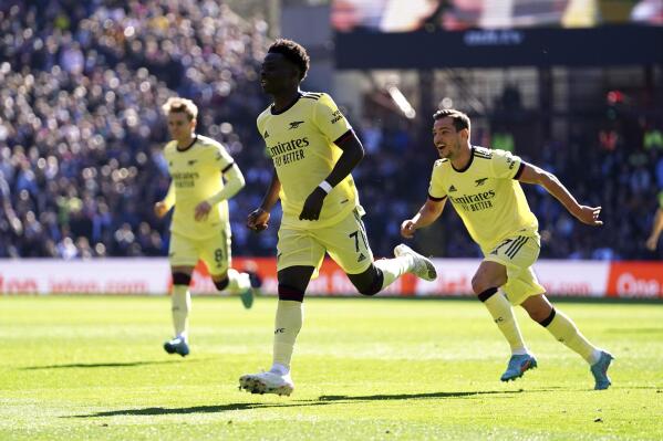 Arsenal's Bukayo Saka celebrates scoring the opening goal during the English Premier League soccer match between Aston Villa and Arsenal at Villa Park, Birmingham, England, Saturday, March 19, 2022. (Nick Potts/PA via AP)
