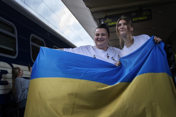 Ukrainian rapper alyona alyona, left, and singer Jerry Heil hold the Ukrainian flag as they pose for the media before departing from the main train station in Kyiv, Ukraine, Thursday, April 25, 2024. Ukraine’s entrants in the pan-continental music competition, the female duo of rapper alyona alyona and singer Jerry Heil set off from Kyiv for the competition on Thursday. In wartime, that means a long train journey to Poland, from where they will travel on to next month’s competition in Malmö, Sweden. (AP Photo/Francisco Seco)