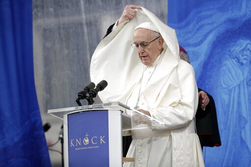 An aide adjusts Pope Francis' mantle as he delivers his speech at the Knock Shrine, in Knock, Ireland, Aug. 26, 2018. (AP Photo/Gregorio Borgia, File)