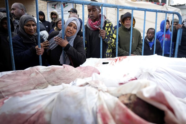 Palestinians mourn the relatives killed in the Israeli air and ground offensive on the Gaza Strip at a hospital in Deir al Balah on Friday, Jan. 26, 2024. (AP Photo/Adel Hana)