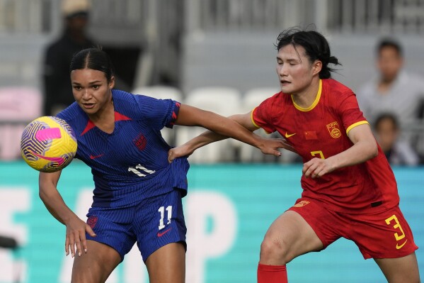 United States forward Sophia Smith (11) vies for the ball with China defender Dou Jiaxing during the first half of a women's International friendly soccer match, in Fort Lauderdale, Fla., Saturday, Dec. 2, 2023. (AP Photo/Rebecca Blackwell)