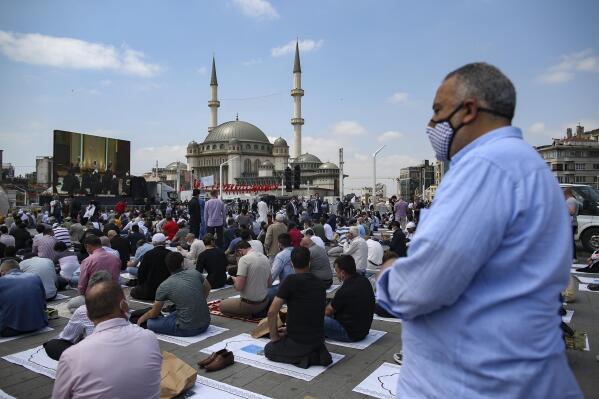 People pray outside the newly built Taksim Mosque at the Taksim Square in Istanbul, Friday, May 28, 2021. Turkish President Recep Tayyip Erdogan inaugurated landmark mosque in Istanbul's Taksim Square, fulfilling a long-time ambition to build a Muslim house of worship at the city's main public space that has become an emblem of the modern Turkish Republic. (AP Photo/Emrah Gurel)