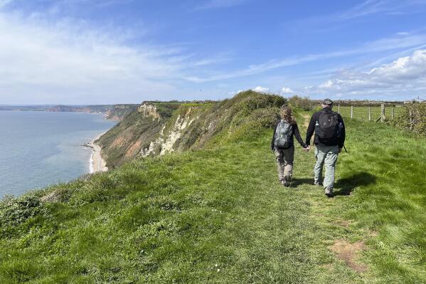 Lauren Finkle, left, and Bob Finkle walk along the cliffs just west of Branscombe, in southern England, along the famous 630-mile South West Coast Path, on April 25, 2023. (Steve Wartenberg via AP)