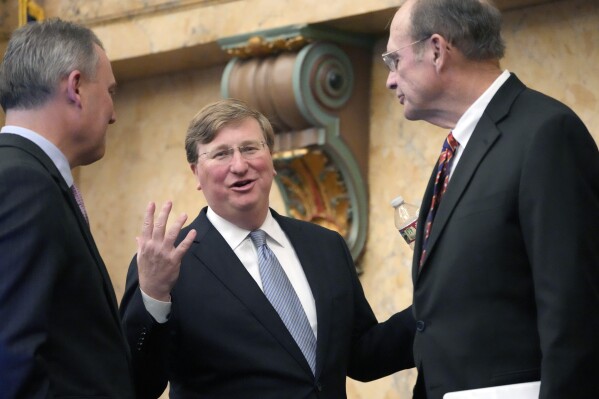 FILE - Mississippi Republican Gov. Tate Reeves, center, confers with Mississippi House Speaker Jason White, R-West, left, and Republican Lt. Gov. Delbert Hosemann, after his State of the State address to a joint session of the Mississippi State Legislature, Monday, Feb. 26, 2024, at the state Capitol in Jackson, Miss. Reeves signed legislation Wednesday, May 8, 2024, to change Mississippi's school funding formula beginning July 1, 2024. (AP Photo/Rogelio V. Solis, File)