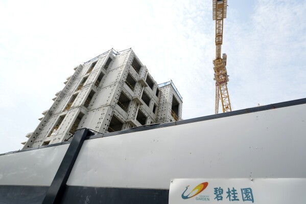FILE - The logo for Country Garden developer is seen near a Country Garden One World City project under construction on the outskirts of Beijing on Aug. 17, 2023. Chinese property developer Country Garden warned Tuesday, Oct. 10, that it cannot repay on time a 470 million Hong Kong dollar ($60 million) loan in the latest sign of distress in the industry after Beijing clamped down on mounting debts in the industry. (AP Photo/Ng Han Guan, File)