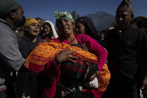 A woman holds the lifeless body of her grand child killed in earthquake in Jajarkot district, northwestern Nepal, Sunday, Nov. 5, 2023. Friday night’s earthquake in the district killed more than hundred people while more than fifty were killed in the neighboring Rukum district, officials said. (AP Photo/Niranjan Shrestha)