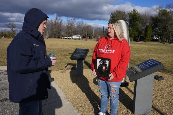 Eric Pranger and Shannon Doughty talk by a memorial, Saturday, Dec. 21, 2024, in Westfield, Ind. (AP Photo/Darron Cummings)