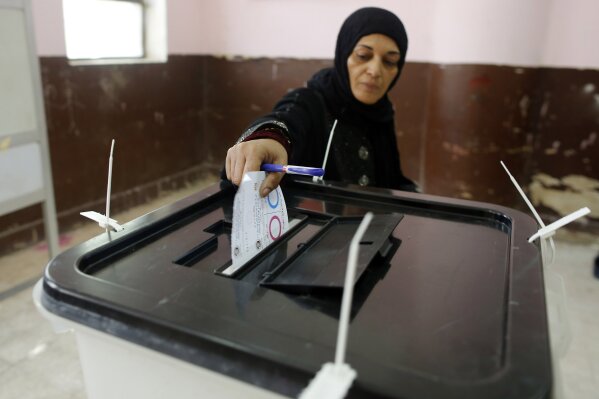 
              A voter casts her ballot on constitutional amendments during the first day of three-day voting at a polling station in Cairo, Egypt, Saturday, April 20, 2019. Egyptians are voting on constitutional amendments that would allow President Abdel-Fattah el-Sissi to stay in power until 2030. (AP Photo/Amr Nabil)
            