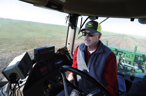 Tim Black uses his tractor's GPS system while planting grass seed on his Muleshoe, Texas, farm on Monday, April 19, 2021. The longtime corn farmer now raises cattle and plants some of his pasture in wheat and native grasses because the Ogallala Aquifer, needed to irrigate crops, is drying up. (AP Photo/Mark Rogers)