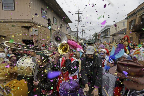 As celebridades tocam a música da banda de cobre no início da carreira da St. Ann Mardi Grass Association em Nova Orleans, 17 de fevereiro de 2015. (AP Photo/Gerald Herbert, arquivo)