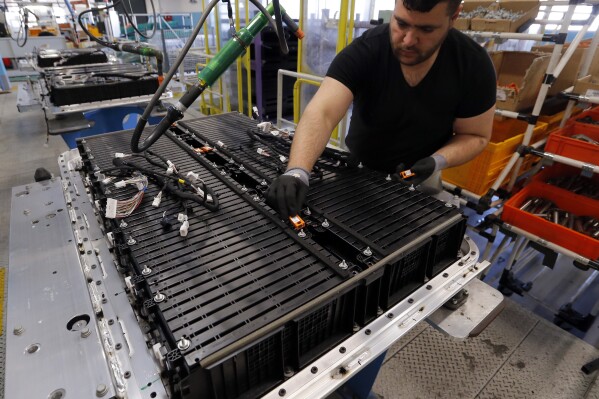 A Renault employee works on the batteries of the the Zoe electric car, on the assembly line of the Renault plant in Flins, west of Paris, France, Wednesday, April 20, 2016. The mining of minerals critical to electric vehicle batteries and other green technologies in Congo has led to human rights abuses, including forced evictions and physical assault. That's according to a report Tuesday from Amnesty International and another rights group. (AP Photo/Francois Mori)