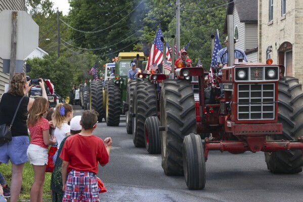 Children watch tractors in a parade in Waubeka, Wis., on June 9, 2024. Old Glory is venerated annually in Waubeka, the small town that lays claim to the first Flag Day. (AP Photo/Teresa Crawford)