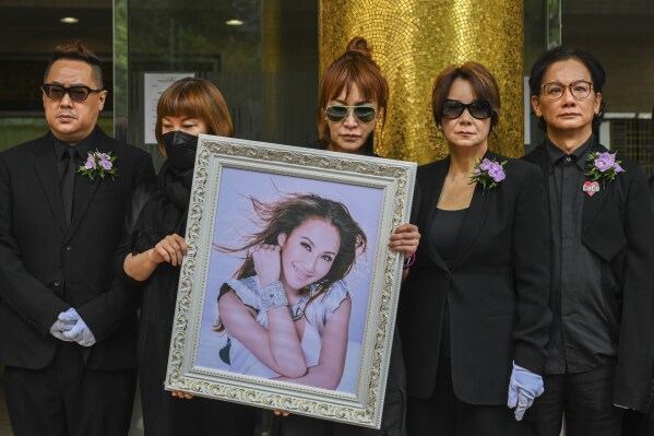 Relatives hold a photo of Coco Lee after her funeral in Hong Kong, Tuesday, Aug. 1, 2023. Lee was being mourned by family and friends at a private ceremony Tuesday a day after fans paid their respects at a public memorial for the Hong Kong-born entertainer who had international success. (AP Photo/Billy H.C. Kwok)