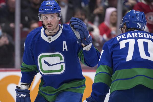 Vancouver Canucks' J.T. Miller, left, talks to Tanner Pearson during the second period of an NHL hockey game against the Montreal Canadiens in Vancouver, on Wednesday, March 9, 2022. (Darryl Dyck/The Canadian Press via AP)