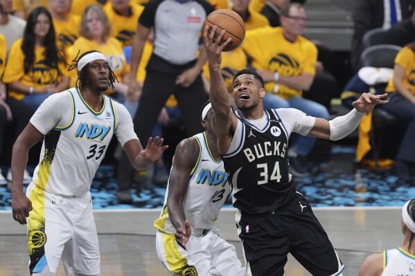 Milwaukee Bucks' Giannis Antetokounmpo (34) heads to the basket as Indiana Pacers' Myles Turner (33) defends during the first half of a first-round NBA basketball playoff game, Saturday, April 19, 2025, in Indianapolis. (AP Photo/Michael Conroy)