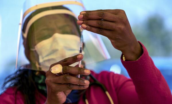 FILE - In this May 25, 2021, file photo, a health worker prepares a dose of the Pfizer coronavirus vaccine at the Orange Farm Clinic near Johannesburg. In the global race to vaccinate people against COVID-19, Africa is tragically at the back of the pack. (AP Photo/Themba Hadebe, File)