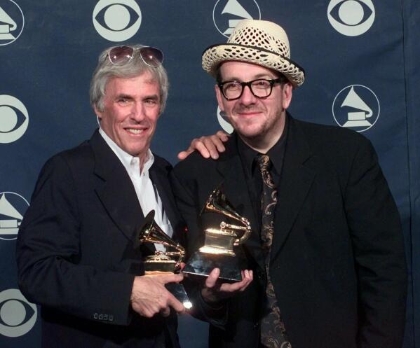 FILE - Burt Bacharach, left, and Elvis Costello hold their awards for best pop collaboration with vocals with "I Still Have That Other Girl" during the 41st Annual Grammy Awards in Los Angeles on Feb. 24, 1999. Bacharach died of natural causes Wednesday, Feb. 8, 2023, at home in Los Angeles, publicist Tina Brausam said Thursday. He was 94. (AP Photo/Kevork Djansezian, File)
