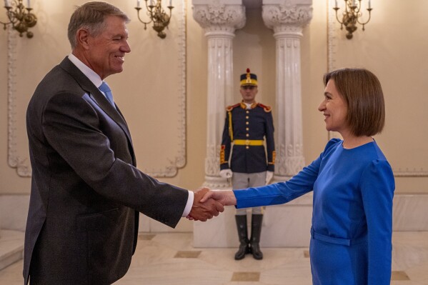 Romania's President Klaus Iohannis, left, shakes hands with Moldova's President Maia Sandu at the Cotroceni Presidential Palace in Bucharest, Romania, Wednesday, Sept. 6, 2023. Romania hosts the two-day Three Seas Initiative Summit and Business Forum, bringing together high ranking officials from twelve EU member states between the Baltic, Black and Adriatic seas. (AP Photo/Vadim Ghirda)