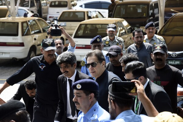 FILE - Pakistan's former Prime Minister Imran Khan, center, arrives to appear at a Supreme Court in Islamabad, Pakistan, Monday, July 24, 2023. Pakistan’s top court on Wednesday, Dec. 13, 2023 allowed military courts to resume the trials of more than 100 supporters of former Prime Minister Imran Khan on charges of attacking military installations during violent demonstrations that broke out following Khan’s arrest in May. The latest order by the Supreme Court came less than two months after five judges on the same court stopped the trial of 103 civilians who were arrested as part of a crackdown on Khan’s party. (AP Photo/W.K. Yousafzai, File)