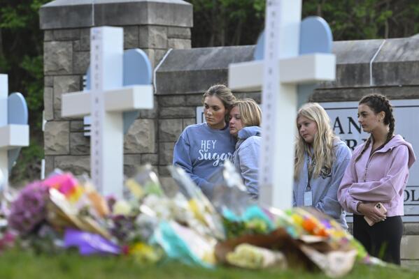 FILE - Students at a nearby school pay respects at a memorial for the people who were killed, at an entry to Covenant School, Tuesday, March 28, 2023, in Nashville, Tenn. Six people were killed at the private school and church yesterday by a shooter. The U.S. is setting a record pace for mass killings in 2023, replaying the horror in a deadly loop roughly once a week so far this year. The bloodshed overall represents just a fraction of the deadly violence that occurs in the U.S. annually. (AP Photo/John Amis, File)