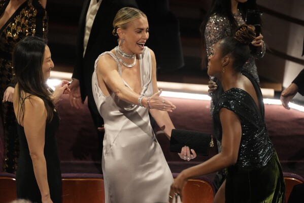 Charlize Theron, center, and Issa Rae speak during the Oscars on Sunday, March 10, 2024, at the Dolby Theatre in Los Angeles. (AP Photo/Chris Pizzello)