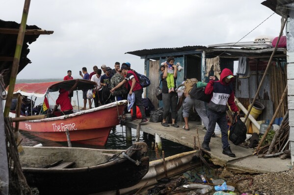 Migrantes venezolanos llegan a la isla panameña de Gardi Sugdub, en el Caribe, el 23 de febrero de 2025, para embarcar rumbo a Colombia tras abandonar sus esperanzas de llegar a Estados Unidos cuando ya estaban en el sur de México debido a la campaña antiimigración de Donald Trump. (AP Foto/Matías Delacroix)