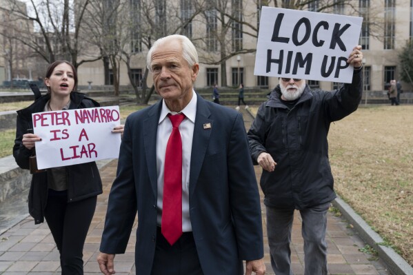 FILE - Former Trump White House official Peter Navarro, followed by demonstrators, leaves the U.S. Federal Courthouse in Washington, Jan. 25, 2024. An appeals court Thursday, March 14, denied Navarro’s bid to stave off his jail sentence on contempt of Congress charges for refusing to cooperate with a congressional investigation into the Jan. 6, 2021, attack on the U.S. Capitol. Navarro has been ordered to report to a federal prison by March 19. (AP Photo/Jose Luis Magana, File)