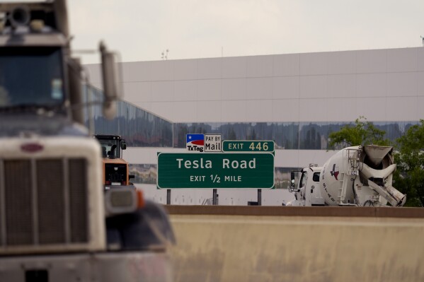 Vehicles pass the Tesla Gigafactory, Thursday, June 13, 2024, in Austin, Texas. Tesla shareholders are charting the future of the electric vehicle company as they wrap up voting whether or not to restore CEO Elon Musk's massive pay package that was thrown out by a Delaware judge. (AP Photo/Eric Gay)