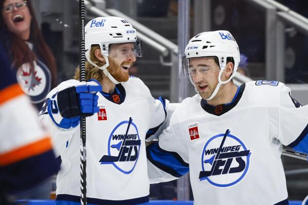 Winnipeg Jets forward Kyle Connor, left, celebrates his goal against the Edmonton Oilers with Neal Pionk during the third period of an NHL hockey game Saturday, Dec. 31, 2022, in Edmonton, Alberta. (Jeff McIntosh/The Canadian Press via AP)