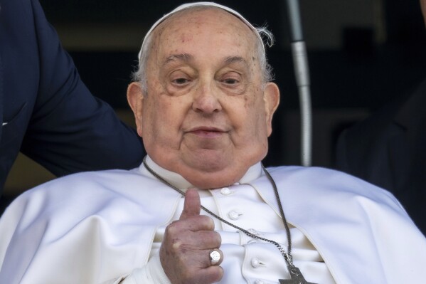 Pope Francis appears at a window of the Agostino Gemelli Polyclinic in Rome, March 23, 2025, where he has been treated for bronchitis and bilateral pneumonia since Feb. 14. (AP Photo/Domenico Stinellis)