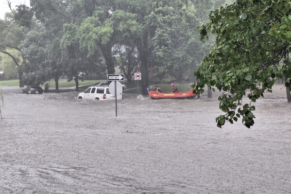 This photo provided by Colin Fee, a vehicle is surrounded by flood waters as heavy rains caused flash flooding in the Wichita area of south-central Kansas forcing firefighters to rescue dozens of people, including stranded motorists on Tuesday, June 3, 2025. (Colin Fee via AP)