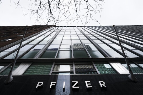 File - The Pfizer name is displayed at the company's headquarters, Feb. 5, 2021, in New York. The pharmaceutical giant dropped race-based eligibility requirements for a fellowship program designed for college students of Black, Latino and Native American descent, even though a judge had dismissed a lawsuit against the program two months earlier. (AP Photo/Mark Lennihan, File)