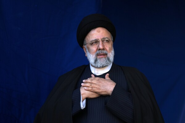FILE- Iranian President Ebrahim Raisi places his hands on his heart as a gesture of respect to the crowd during the funeral ceremony of the victims of a bomb explosion in the city of Kerman about 510 miles (820 kms) southeast of the capital Tehran, Iran, Jan. 5, 2024. (AP Photo/Vahid Salemi, File)