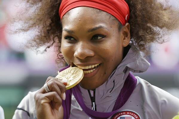 This Aug. 4, 2012 file photo shows Serena Williams posed with her 2012 Summer Olympics gold medal during the podium ceremony of the women's singles final match at the All England Lawn Tennis Club at Wimbledon, in London. (AP Photo/Elise Amendola, File)