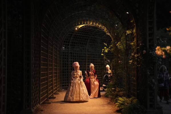 Costumed guests visit the gardens of the Versailles castle before the Great Masked Ball in Versailles, outside Paris, Saturday, June 21, 2025. (AP Photo/Christophe Ena)