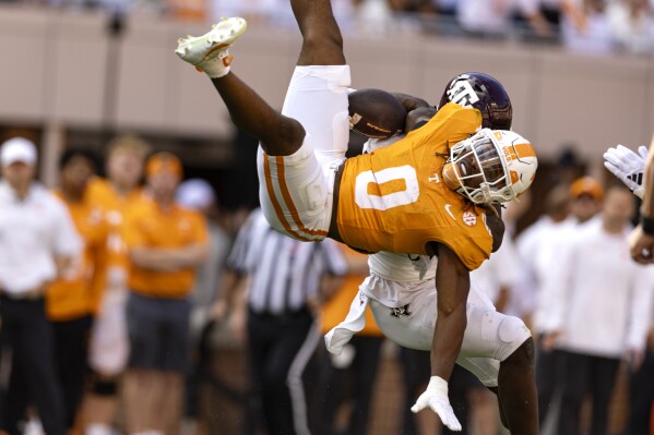 Tennessee running back Jaylen Wright (0) is upended by a Texas A&M defender during the first half of an NCAA college football game Saturday, Oct. 14, 2023, in Knoxville, Tenn. (AP Photo/Wade Payne)